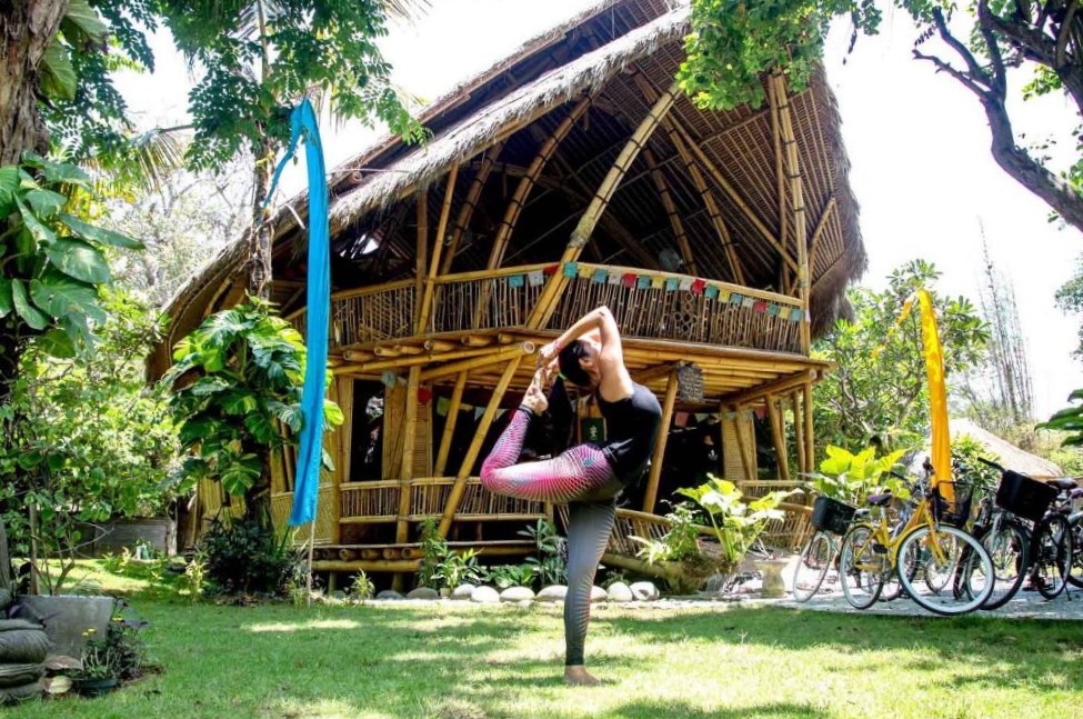 yoga woman in front of tropical yoga shala doing Yoga teacher training in bali